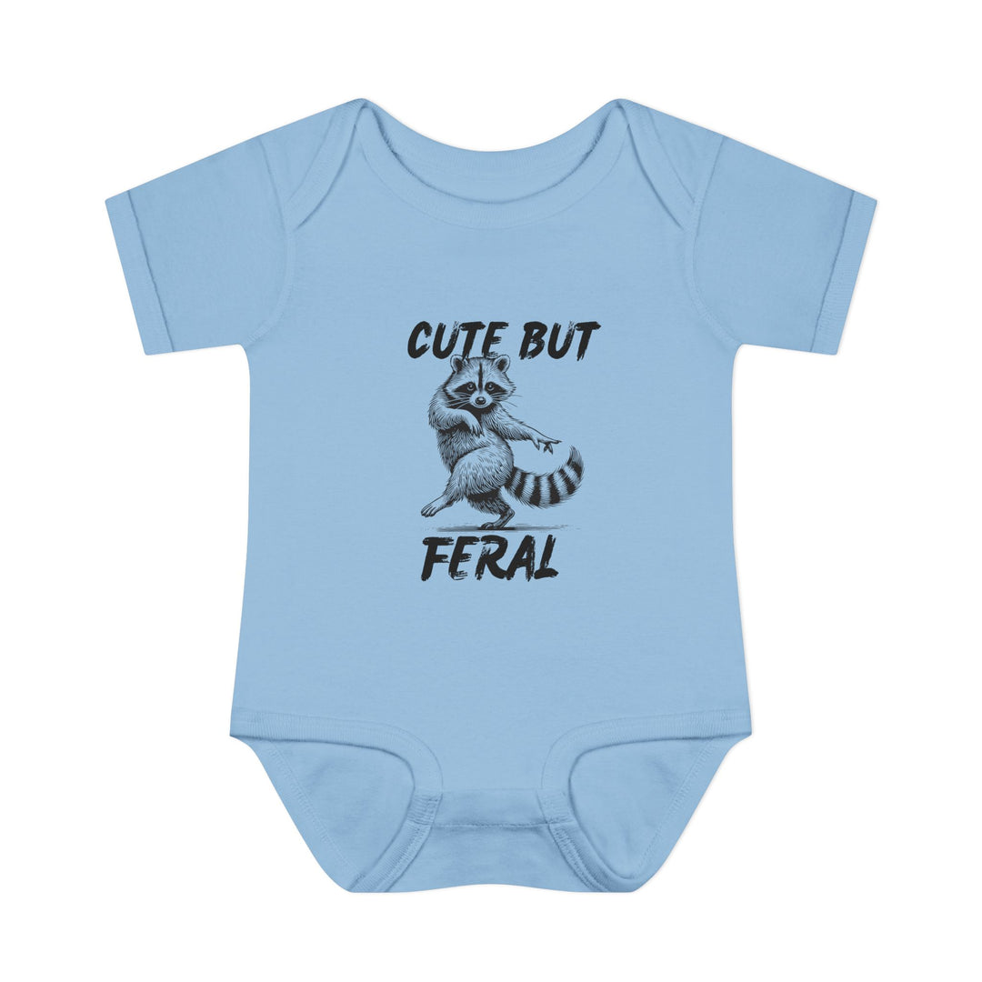 Light-blue Cute But Feral baby onesie with cartoon raccoon, emphasizing comfort with soft, ring-spun cotton and practical lap shoulders. Unisex fit for infants.