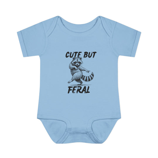 Light-blue Cute But Feral baby onesie with cartoon raccoon, emphasizing comfort with soft, ring-spun cotton and practical lap shoulders. Unisex fit for infants.