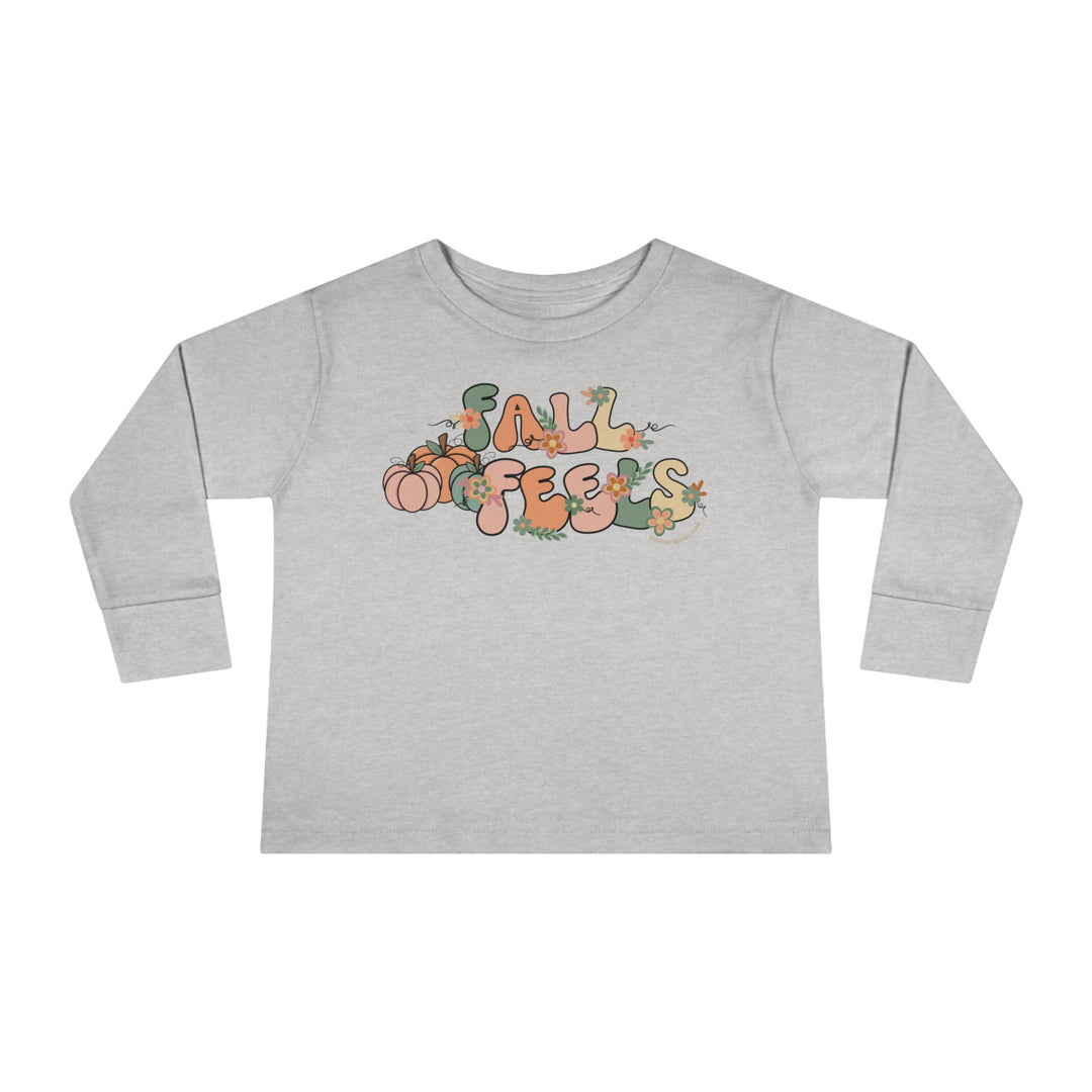 A durable Fall Feels Toddler Long Sleeve Tee crafted from 100% cotton, featuring a graphic design of a bird and flowers. Unisex fit with ribbed collar and EasyTear™ label for comfort and style.