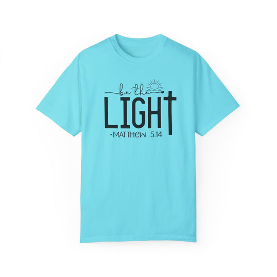A cozy Be the Light Tee in light blue with black text. 100% ring-spun cotton, garment-dyed, relaxed fit, durable double-needle stitching, seamless design for comfort. Ideal for daily wear.
