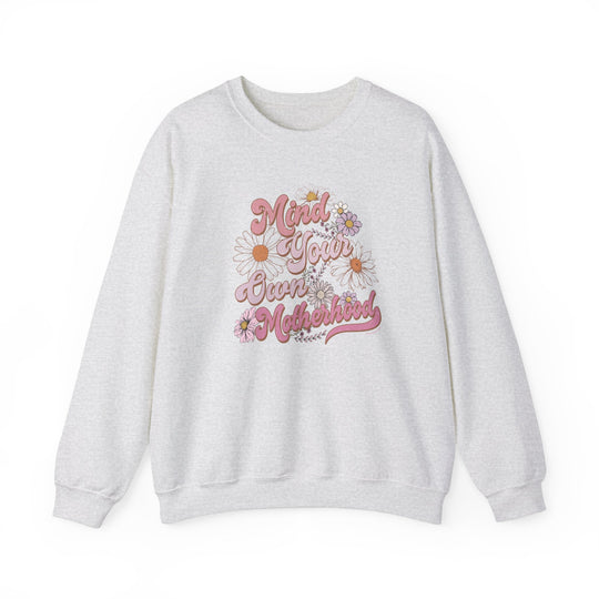 Unisex Mind Your Own Motherhood Crew sweatshirt, white with pink floral and text details. Heavy blend fabric, ribbed knit collar, no itchy seams. Sizes S-5XL. Ideal comfort for any occasion.