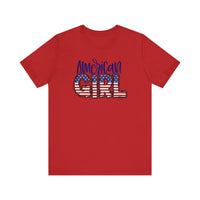 American Girl Tee: Red shirt with flag and text designs. Unisex jersey tee with ribbed knit collar, 100% cotton, retail fit, tear away label. Sizes XS-3XL. Soft, quality fabric for a loved favorite.