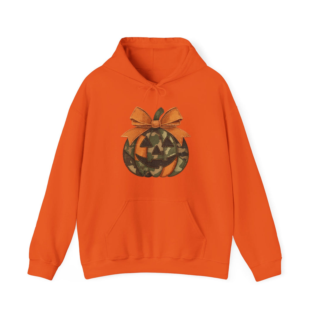 Bright orange Jackie O Hoodie with camo-patterned jack-o-lantern graphic and stitched bow, featuring a kangaroo pocket and matching drawstring for cozy, stylish wear.