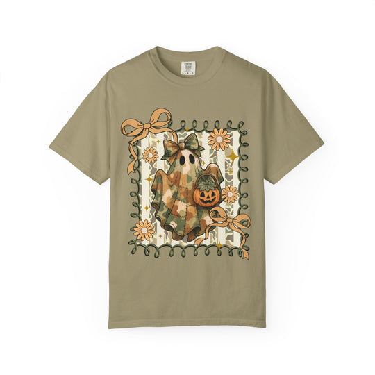 Quilted Ghost Tee features a ghost with a patchwork sheet and bow, holding a jack-o-lantern, framed by curly vines and flowers.