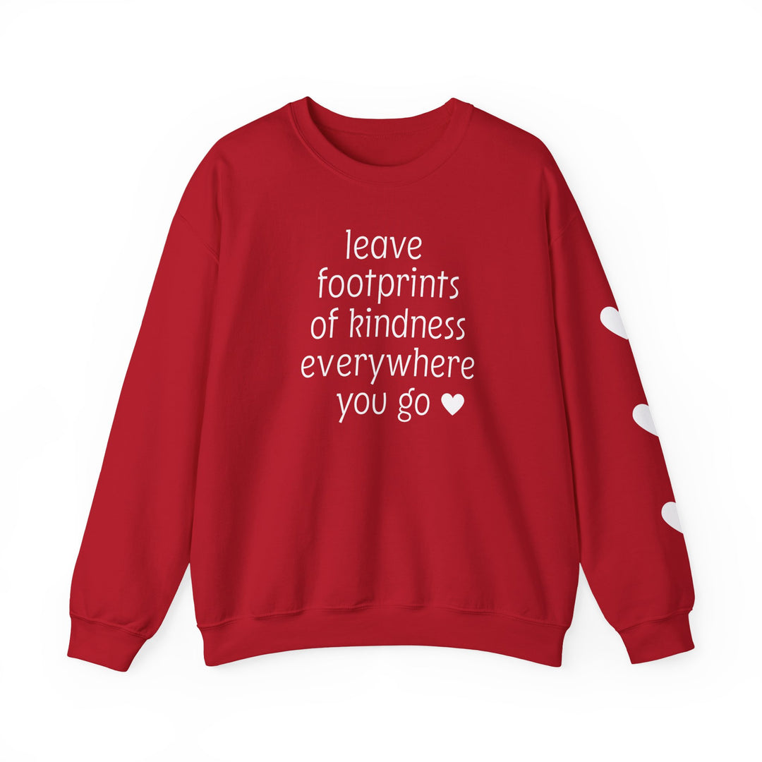Red crew-neck sweatshirt with leave footprints of kindness everywhere you go in white text and heart icons; right sleeve features white heart shapes.