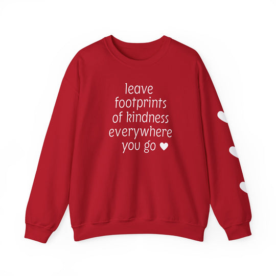 Red crew-neck sweatshirt with leave footprints of kindness everywhere you go in white text and heart icons; right sleeve features white heart shapes.