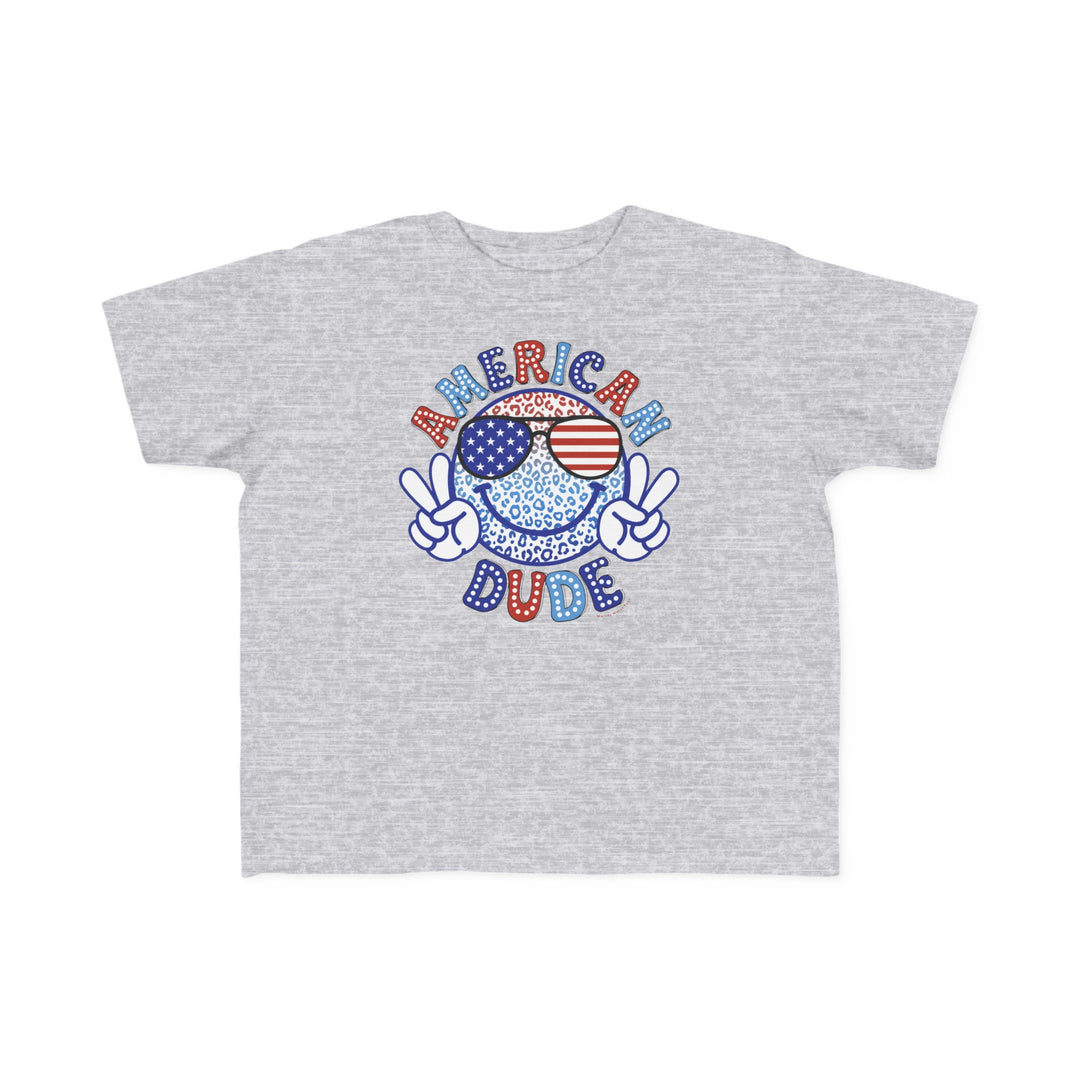 American Dude Toddler Tee featuring a cartoon character design on a grey shirt. Made of 100% combed ringspun cotton, light fabric, tear-away label, and a classic fit. Sizes available: 2T, 3T, 4T, 5-6T.