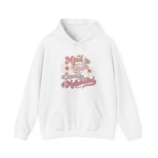 A white Mind Your Motherhood Hoodie sweatshirt with pink text, featuring a kangaroo pocket and matching drawstring. Unisex, heavy blend for warmth and comfort. Ideal for chilly days.