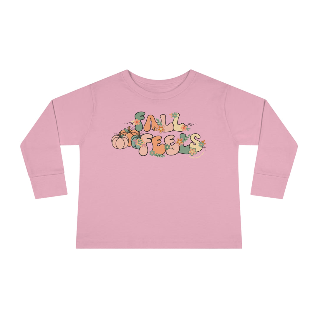 A pink toddler long-sleeve tee with a graphic design featuring words and pumpkins. Made of 100% combed ringspun cotton, with a ribbed collar and EasyTear™ label for comfort and durability.