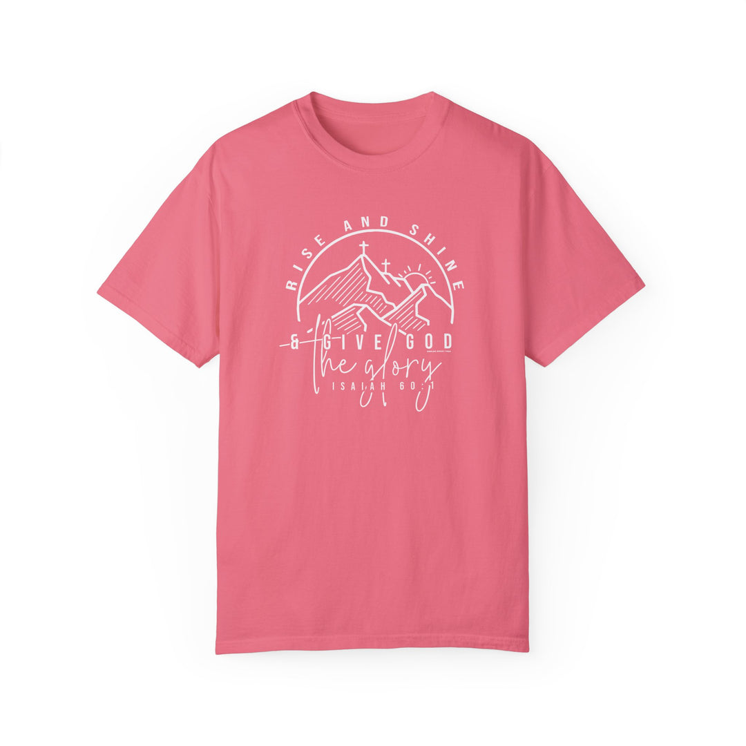 A relaxed fit Rise and Shine Tee, a pink shirt with white text, featuring a cross and mountains logo. Made of 100% ring-spun cotton for coziness and durability, perfect for daily wear.