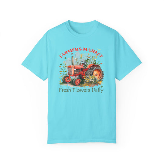Alt text: Fresh Flowers Tee: A blue shirt featuring a tractor design, made of 100% ring-spun cotton. Relaxed fit with double-needle stitching for durability, perfect for daily wear. From Worlds Worst Tees.