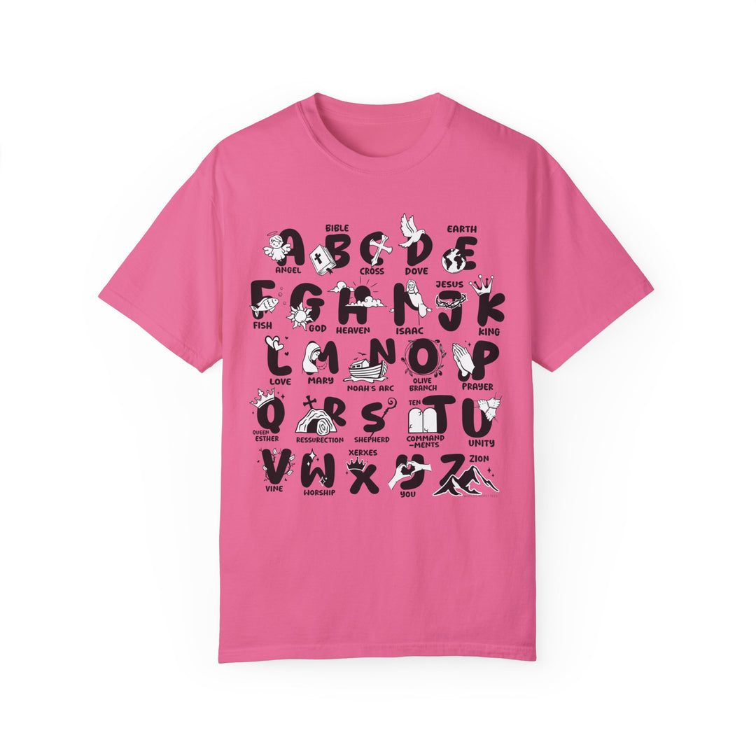A Bible Alphabet Tee in pink with black letters and symbols. Made of 100% ring-spun cotton, garment-dyed for coziness, featuring a relaxed fit and durable double-needle stitching. Ideal for daily wear.
