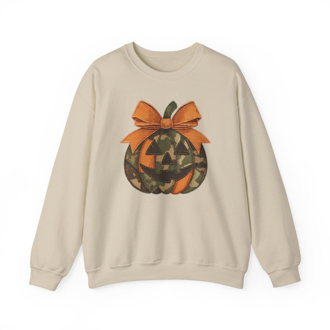 Cream-colored Jackie O Crew sweatshirt featuring a stylized jack-o’-lantern with orange and camouflage segments, topped with an orange bow, ideal for comfort and style.