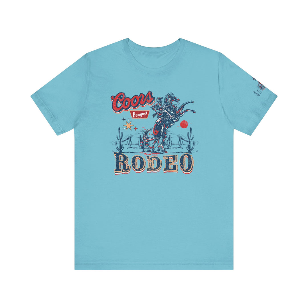 A beloved Coors Rodeo Tee featuring a cowboy on a horse, in soft 100% cotton. Unisex fit with ribbed knit collars, taping on shoulders, and tear-away label. Sizes XS to 3XL.