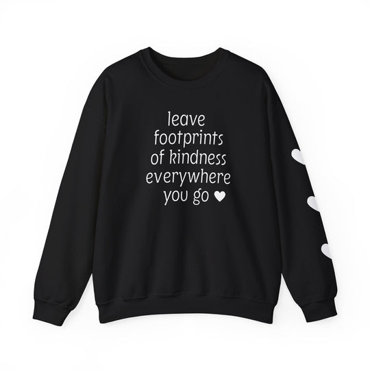 Black crewneck sweatshirt with leave footprints of kindness everywhere you go ♥ slogan and white hearts on sleeve, emphasizing comfort and ethical production.