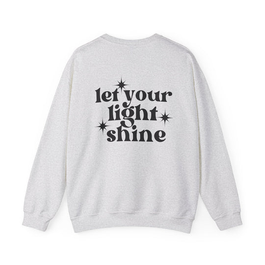 A unisex heavy blend crewneck sweatshirt featuring black text that reads Let Your Light Shine Crew. Made of 50% cotton and 50% polyester, with ribbed knit collar and no itchy side seams. Medium-heavy fabric, loose fit, and true to size.