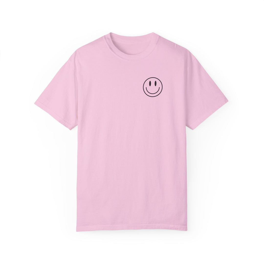 A pink Be the reason Tee, featuring a smiley face graphic. 100% ring-spun cotton, garment-dyed for coziness. Relaxed fit, double-needle stitching for durability, no side-seams for shape retention.