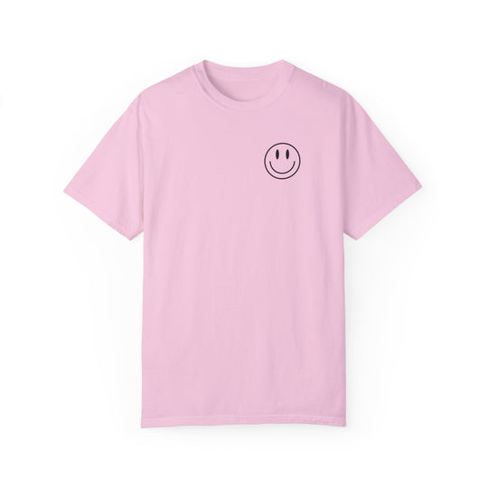 A pink Be the reason Tee, featuring a smiley face graphic. 100% ring-spun cotton, garment-dyed for coziness. Relaxed fit, double-needle stitching for durability, no side-seams for shape retention.