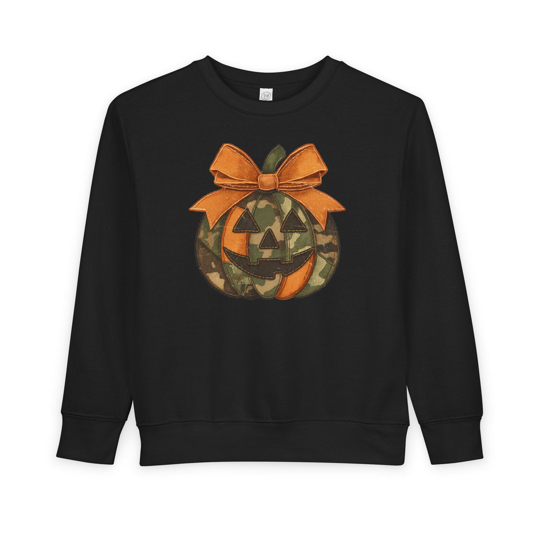 Jackie O Toddler Crew sweatshirt, black with a playful Halloween-themed jack-o-lantern design, featuring orange and camouflage panels, and a stitched orange bow.