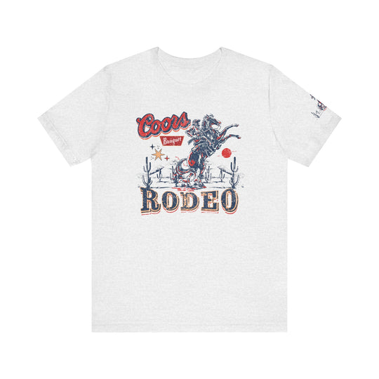 A white Coors Rodeo Tee featuring a cowboy on a horse graphic. Unisex jersey tee with ribbed knit collar, 100% Airlume combed cotton, retail fit, tear away label. Sizes XS to 3XL.