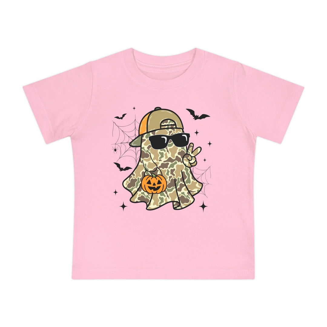 Candy Ghost Baby Tee: Light-pink children’s T-shirt featuring a camo-clad ghost with sunglasses, peace sign, and jack-o’-lantern, surrounded by bats and spiderwebs.