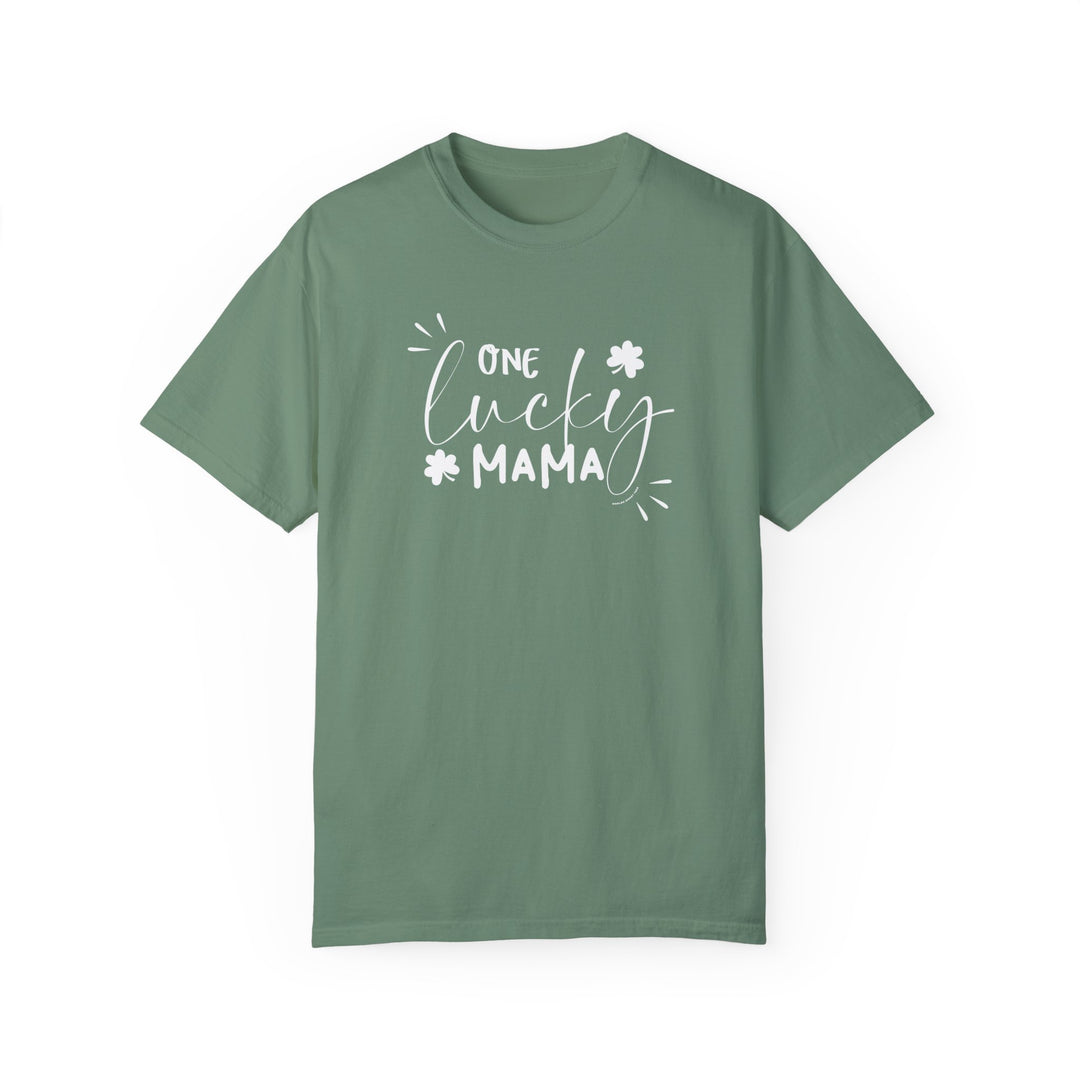 A relaxed fit One Lucky Mama Tee, garment-dyed in green with white text, crafted from 100% ring-spun cotton for extra coziness and durability. Medium weight, double-needle stitching, and seamless design for a tubular shape.