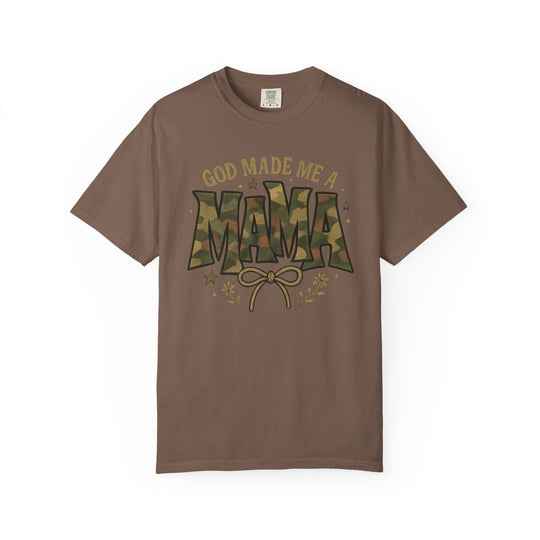 God Made Me a Mama Tee features a camouflage-patterned MAMA graphic with bow and floral accents on a brown, short-sleeve, relaxed-fit, cotton shirt.