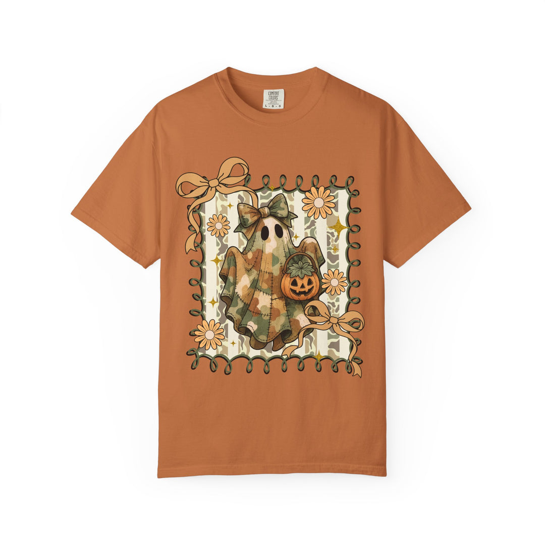 Quilted Ghost Tee: Orange short-sleeve shirt features a patchwork ghost with camouflage, holding a pumpkin, framed by vines, flowers, and bows on a striped background.