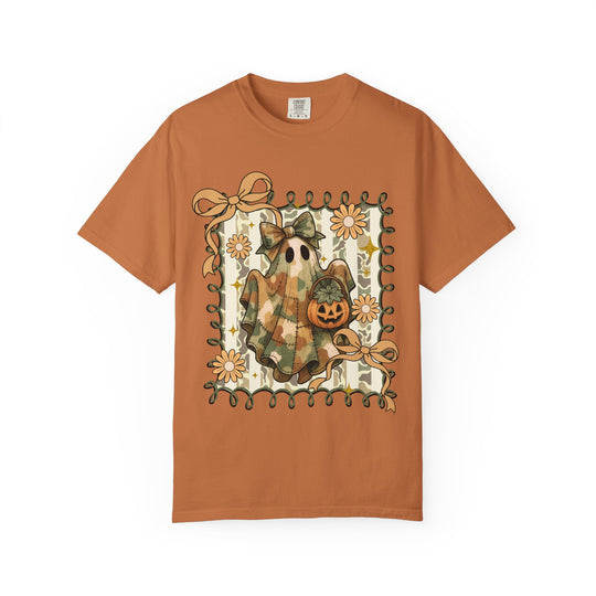 Quilted Ghost Tee: Orange short-sleeve shirt features a patchwork ghost with camouflage, holding a pumpkin, framed by vines, flowers, and bows on a striped background.