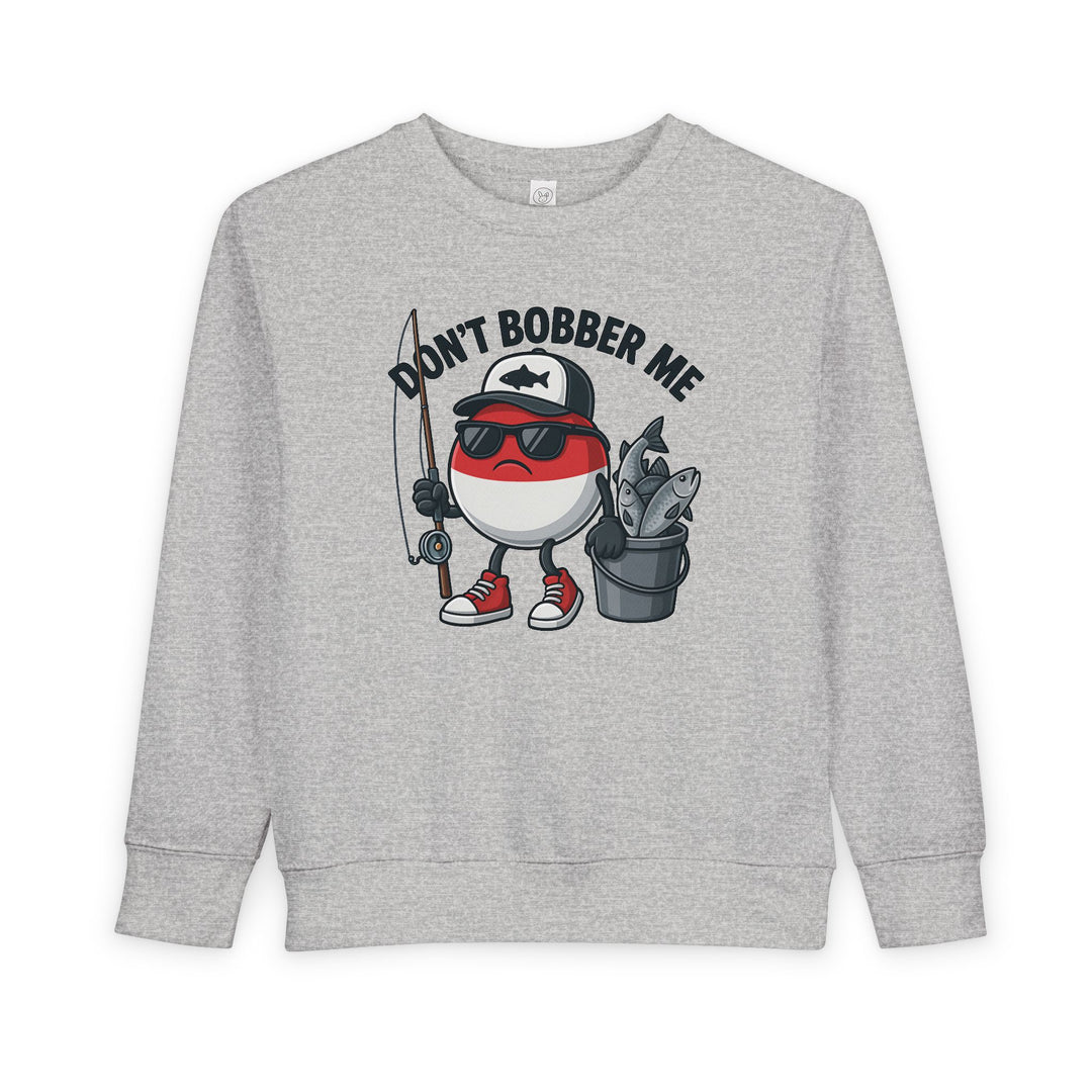 Don't Bobber Me Toddler Crew sweatshirt with cartoon bobber character, sunglasses, cap, holding fishing gear. Cozy, durable, perfect for toddler style and comfort.