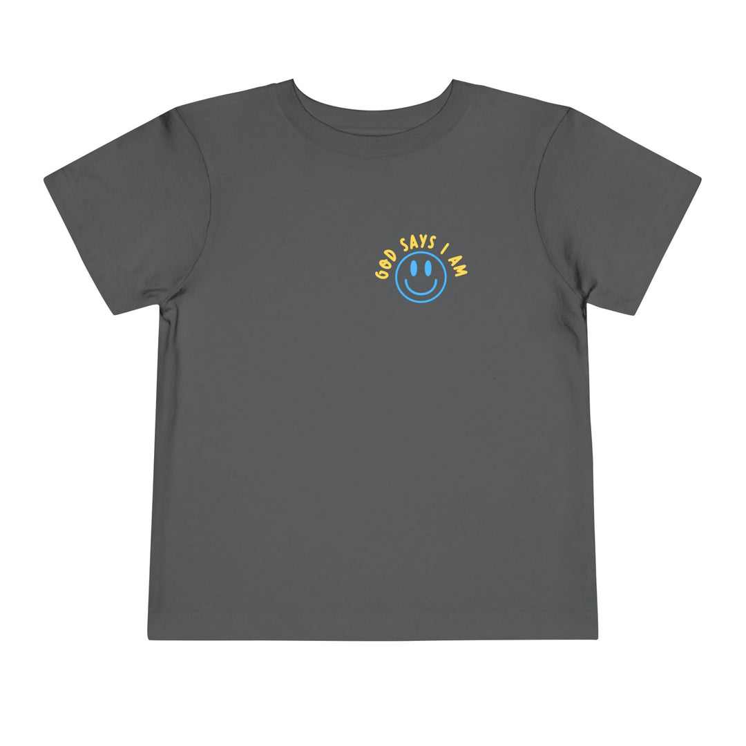 I AM Toddler Tee: Dark gray, short-sleeved T-shirt featuring a smiling face graphic and GOD SAYS I AM text on the chest. Made from soft cotton.