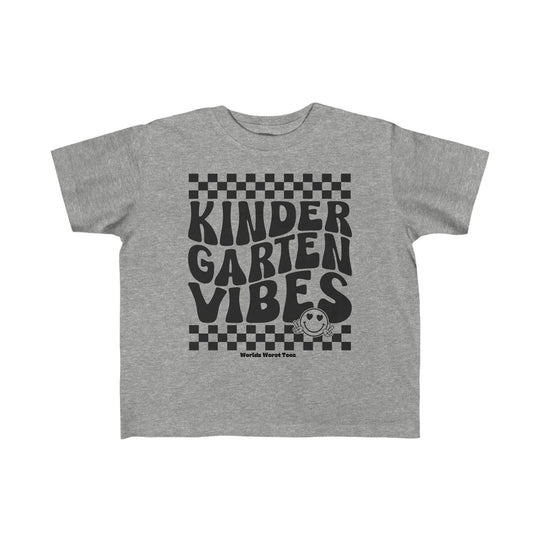 A Kindergarten Vibes Toddler Tee in grey with black text, featuring a durable print perfect for sensitive skin. Made of 100% combed ringspun cotton, light fabric, classic fit, tear-away label, and true-to-size.