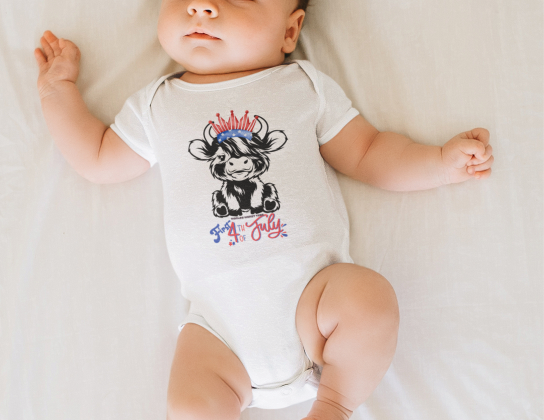 A baby lies on a bed, wearing a 4th of July Family Cowgirl Onesie. This infant fine jersey bodysuit is 100% cotton, featuring ribbed knit bindings, side seams, and plastic snaps for easy changes.