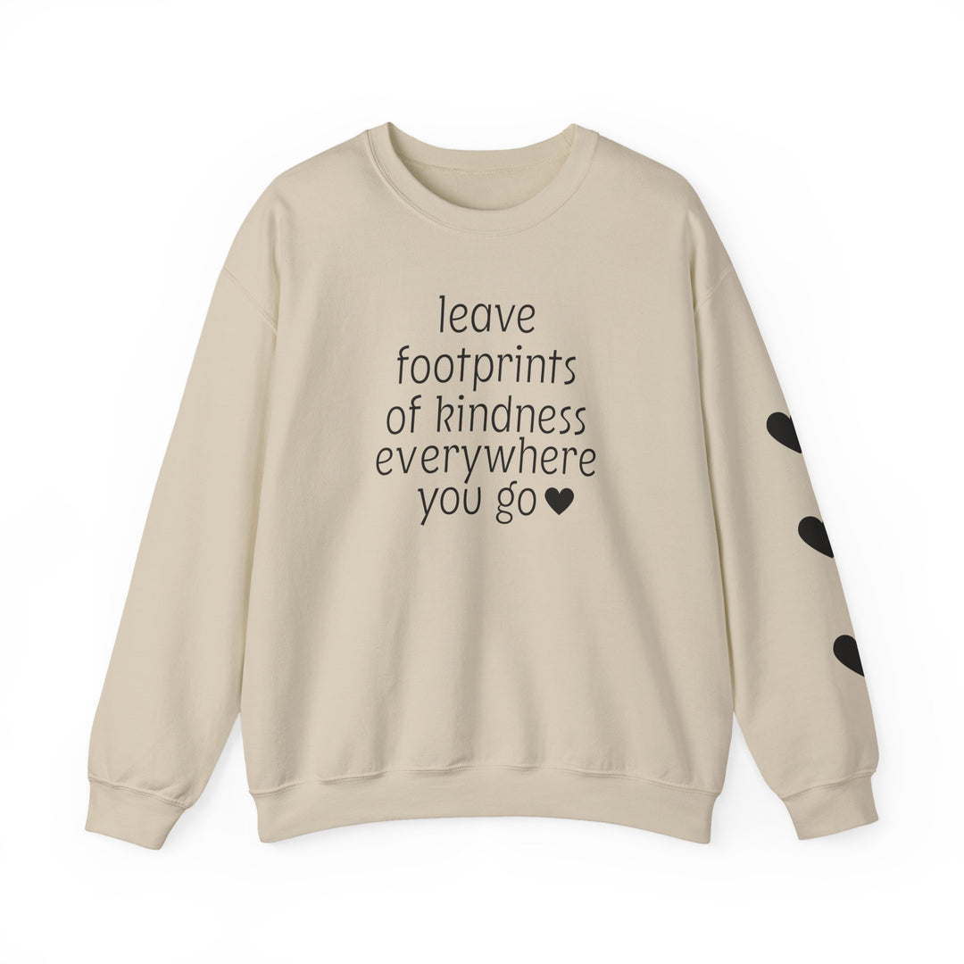 Light-beige crewneck sweatshirt with “leave footprints of kindness everywhere you go ♥” quote across the chest and three black hearts on the right sleeve.