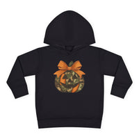 Jackie O Toddler Hoodie featuring a camouflage and orange jack-o’-lantern graphic with an orange bow on the stem, designed for comfort and durability.