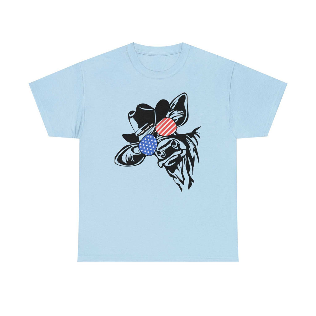 A blue t-shirt featuring a cow with a hat and flag, embodying casual fashion with a classic fit. Unisex heavy cotton tee with ribbed knit collar for comfort and durability. Ideal for 4th of July celebrations.