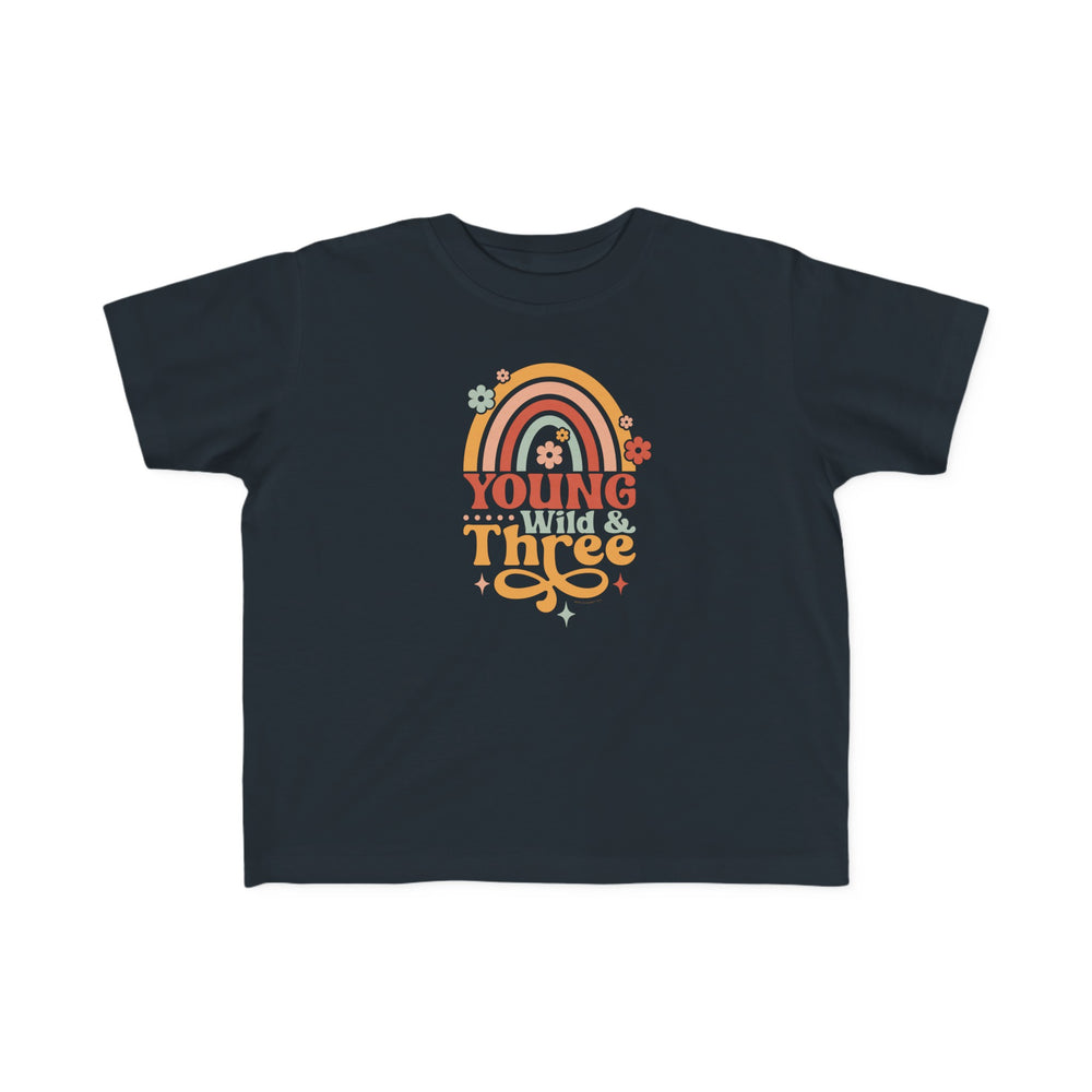 Young Wild and Three Toddler Tee: A black shirt featuring a rainbow, flowers, and text. Soft 100% combed ringspun cotton, light fabric, tear-away label. Perfect for toddlers with a classic fit.