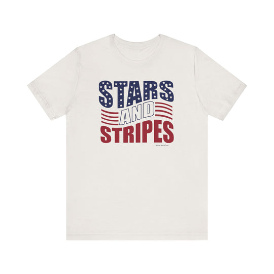 A white Stars and Stripes Tee, featuring red and blue text and a logo. Unisex jersey tee with ribbed knit collars, taping on shoulders, and dual side seams for durability. 100% Airlume combed and ringspun cotton.