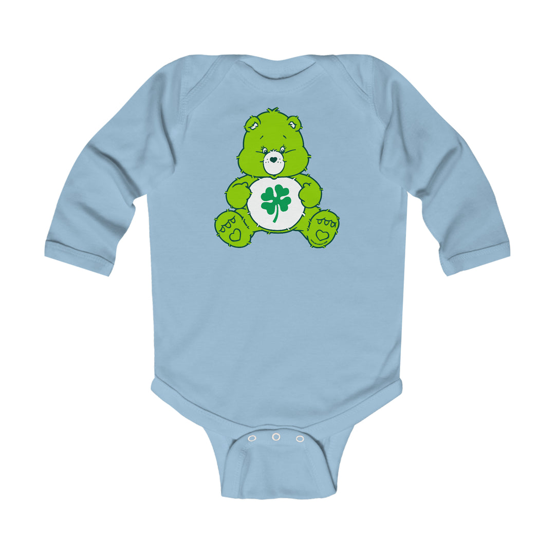 A Lucky Bear Onesie for infants, featuring a green bear design on a blue bodysuit. Made of soft cotton, with ribbed bindings for durability and easy changing snaps. Ideal for comfort and style.