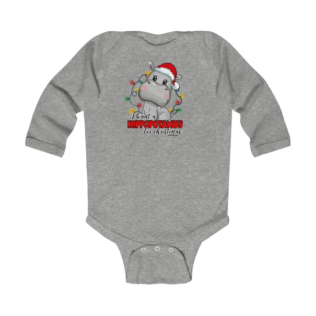 A grey baby bodysuit featuring a cartoon hippo in a Santa hat. Infant long sleeve bodysuit with ribbed bindings for durability and easy changing. 100% combed ring-spun cotton for softness. From 'Worlds Worst Tees'.