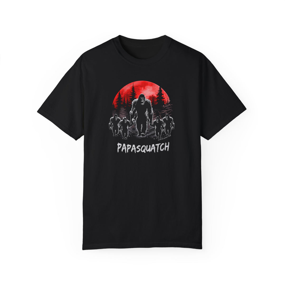 Papasquatch Tee: A black t-shirt featuring a large image of Bigfoot under a red moon. 100% ring-spun cotton, garment-dyed for coziness, with double-needle stitching for durability and a relaxed fit.