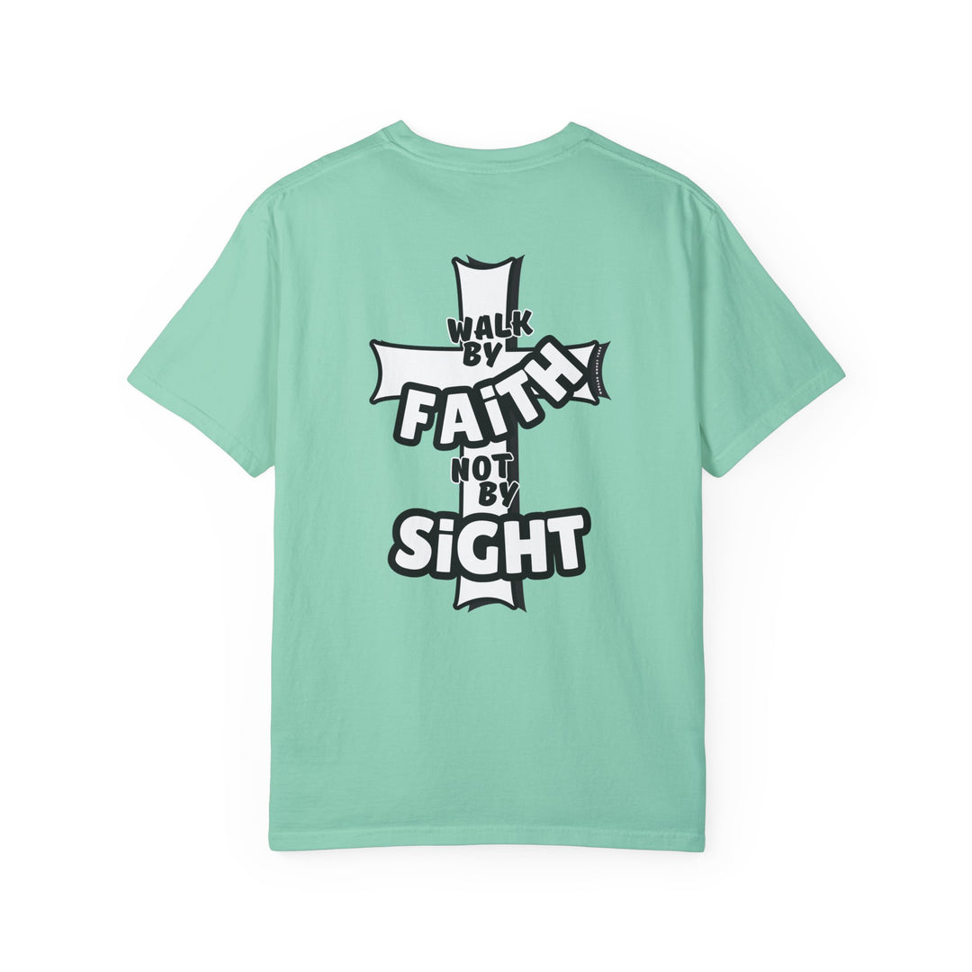 A Walk By Faith Not By Sight Tee, a green shirt with a cross logo and cartoon character, crafted from 100% ring-spun cotton for a cozy, durable, relaxed fit. Ideal for daily wear.
