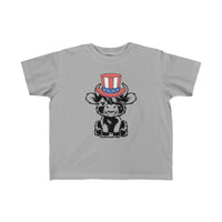 Toddler tee featuring a cartoon cow in a hat, ideal for sensitive skin. 100% combed ringspun cotton, light fabric, classic fit, tear-away label. Perfect for 4th of July family fun.