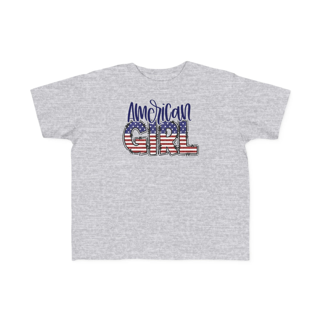 American Girl Toddler Tee featuring a red, white, and blue flag design on a grey shirt. Soft 100% combed ringspun cotton, tear-away label, classic fit. Sizes: 2T, 3T, 4T, 5-6T.