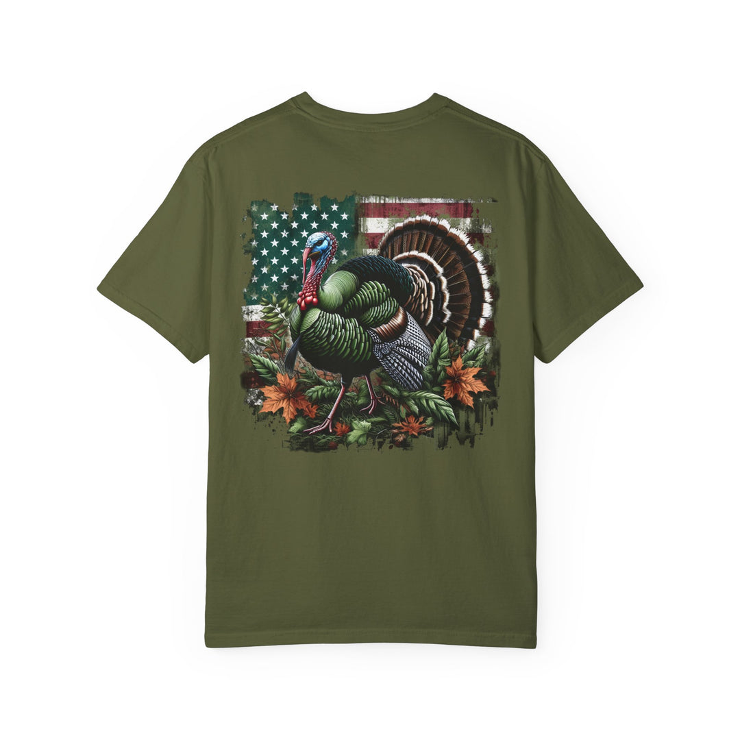 A relaxed fit Turkey Hunting Tee, crafted from 100% ring-spun cotton. Garment-dyed for extra coziness, featuring a turkey design on a green shirt. Durable double-needle stitching, no side-seams for a tubular shape.