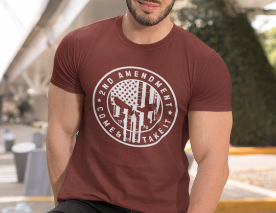 A man wearing a red 2nd Amendment Come and Take It Tee, showcasing a white circle with a flag and a gun design. Unisex jersey tee with ribbed knit collars and taping on shoulders for a comfortable fit.