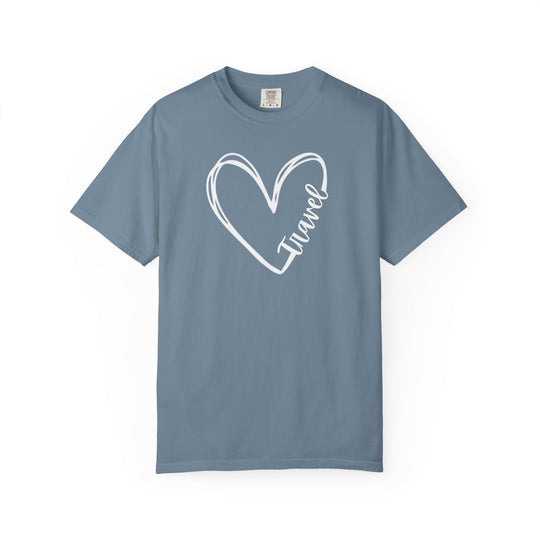 Steel-blue Travel Tee featuring a white hand-drawn heart outline with travel scripted along the heart's side, showcasing a comfortable, relaxed fit.
