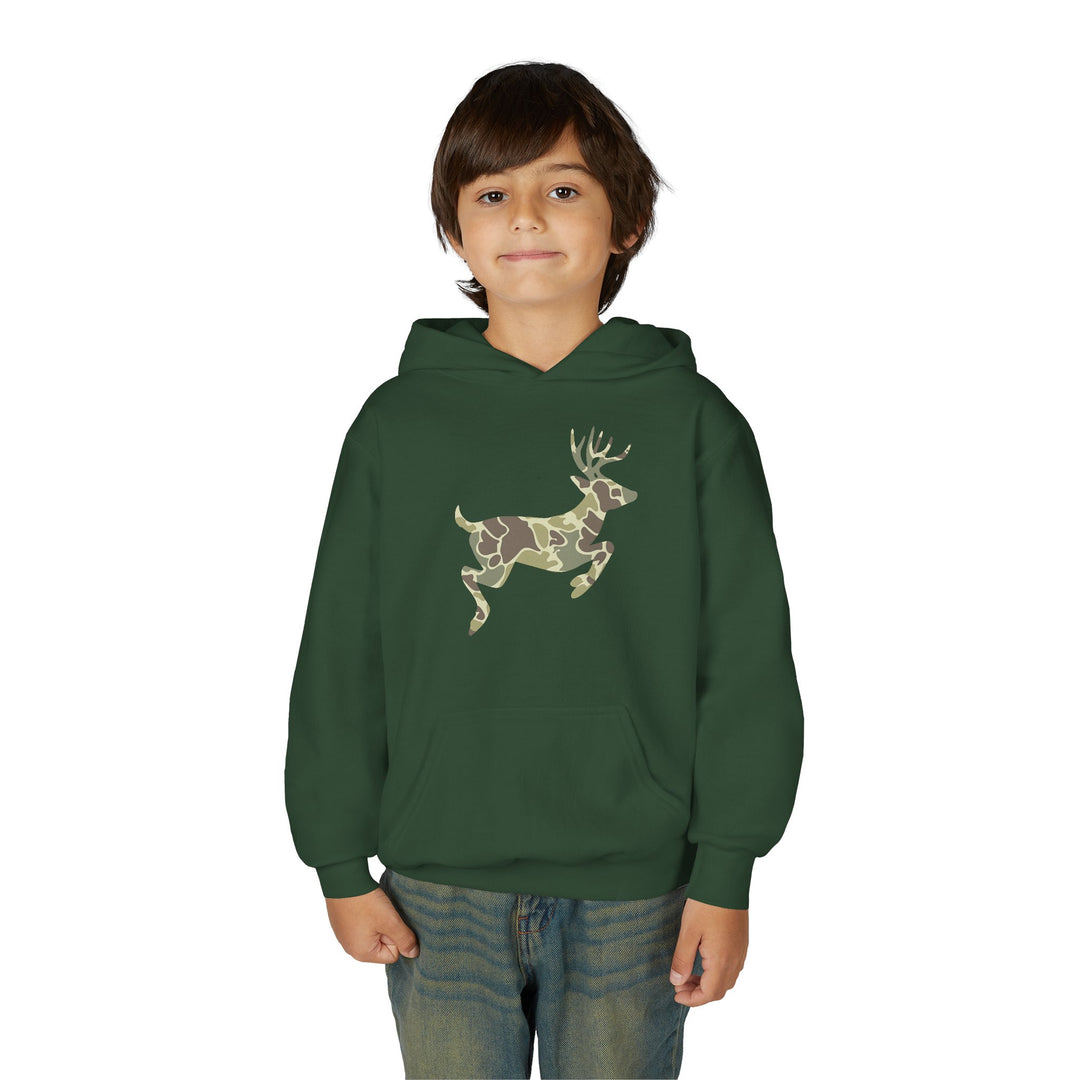 Young boy in a Camo Deer Youth Hoodie with a camouflage deer silhouette, wearing blue jeans, gazes at the camera. The hoodie features a kangaroo pocket.