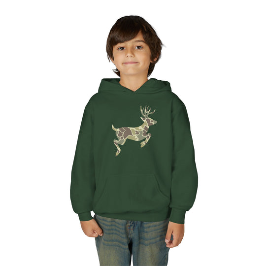 Young boy in a Camo Deer Youth Hoodie with a camouflage deer silhouette, wearing blue jeans, gazes at the camera. The hoodie features a kangaroo pocket.