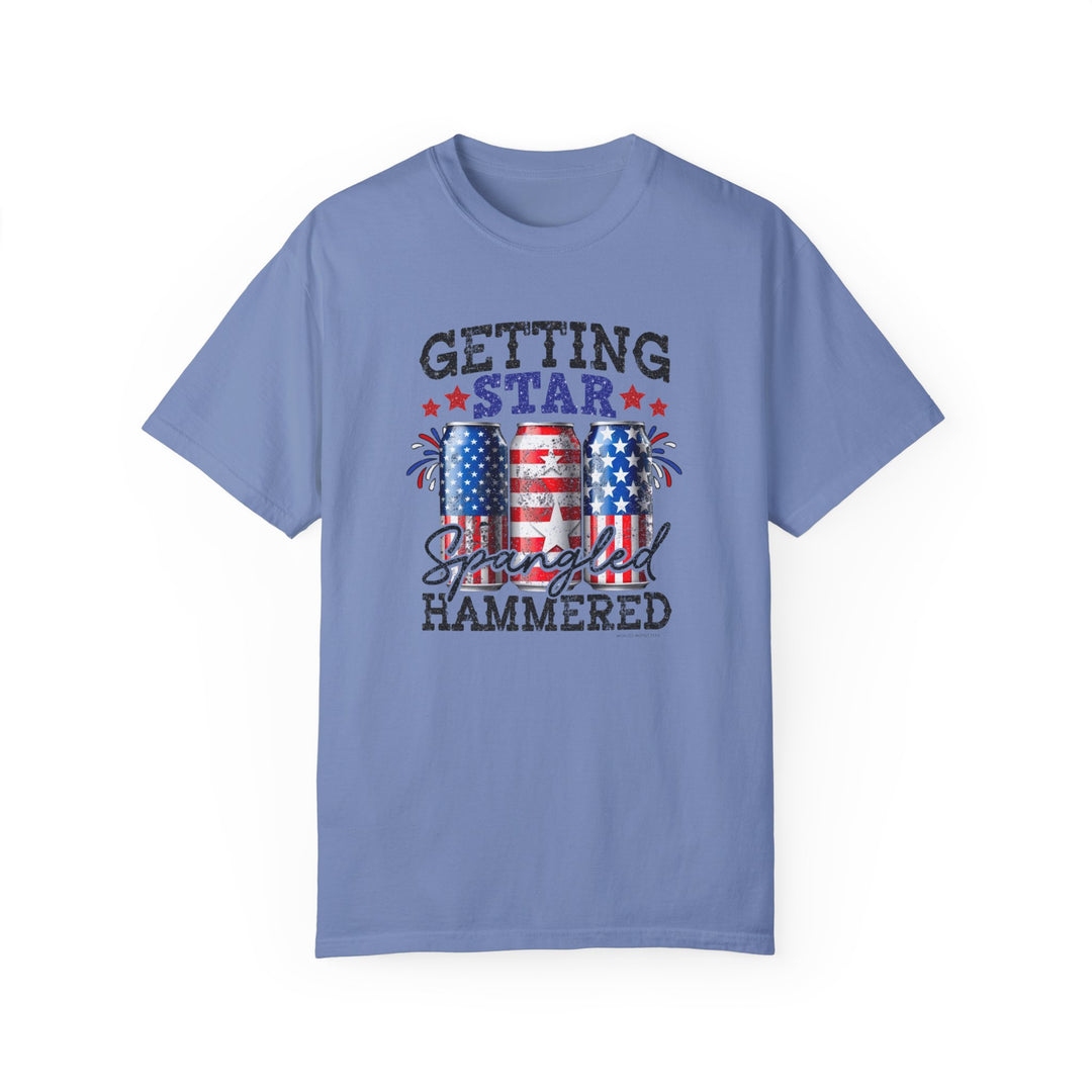 A relaxed fit Star Spangled Hammered Tee, garment-dyed for coziness, crafted from 100% ring-spun cotton. Durable double-needle stitching, no side-seams for tubular shape retention. Medium weight, versatile tee from Worlds Worst Tees.